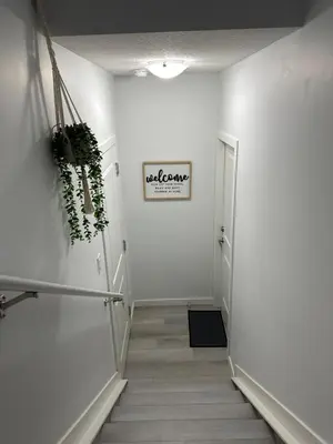 a hallway with white walls and a white hallway at Muaysh Cozy Family suite - Londonderry Mall in Edmonton