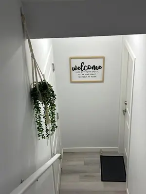 a hallway with a welcome sign on a white wall at Muaysh Cozy Family suite - Londonderry Mall in Edmonton