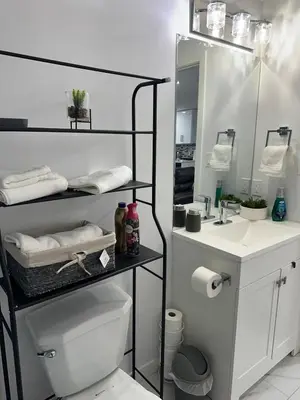 a bathroom with a toilet and a sink and a mirror at Muaysh Cozy Family suite - Londonderry Mall in Edmonton