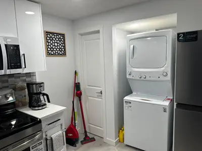 a kitchen with a refrigerator and a tv on top at Muaysh Cozy Family suite - Londonderry Mall in Edmonton