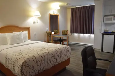 a hotel room with a bed and a small kitchen at Canadas Best Value Inn & Suites-Castlegar in Castlegar