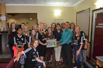 a group of people posing for a picture with a plaque at Canadas Best Value Inn & Suites-Castlegar in Castlegar