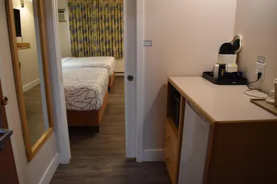 a small room with a bedroom with a bed and a mirror at Canadas Best Value Inn & Suites-Castlegar in Castlegar