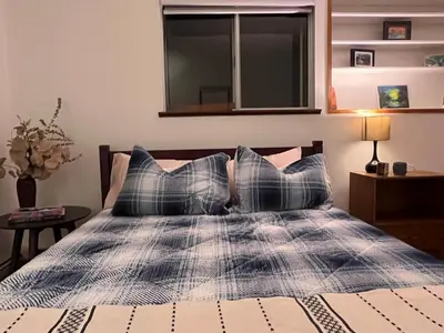 a bedroom with a bed with a window and pillows at Peter's Place - Spacious 2Bed & Bath Suite in Surrey