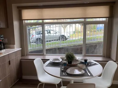 a white table and chairs in a kitchen with a window at The Scandinavian House by Maple Dream Homestay- near Sky train in Vancouver