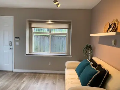 a living room with a couch and a window at The Scandinavian House by Maple Dream Homestay- near Sky train in Vancouver