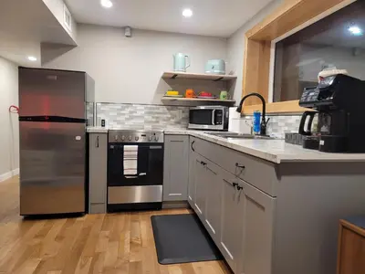a kitchen with a stainless steel refrigerator and a sink at The Suite Treat in Whitehorse