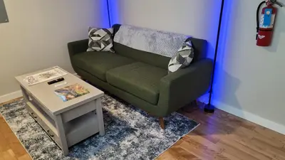 a green couch in a room with a table at The Suite Treat in Whitehorse