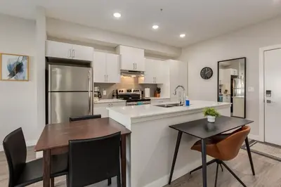 a kitchen with a wooden table and a dining room at Pet Friendly 2 Bed Close to Downtown in Calgary