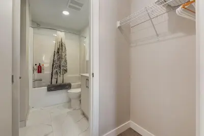 a white bathroom with a toilet and a shower at Pet Friendly 2 Bed Close to Downtown in Calgary