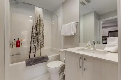 a white bathroom with a toilet and a sink at Pet Friendly 2 Bed Close to Downtown in Calgary