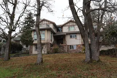 a large house with trees in front of it at 2 BR Spacious Ground Level Suite in Victoria
