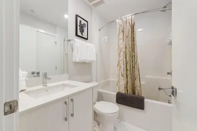 a white bathroom with a toilet and a sink at Pet Friendly, Free Parking, Close to Downtown in Calgary