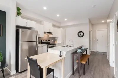 a kitchen with a stainless steel refrigerator and a table at Pet Friendly, Free Parking, Close to Downtown in Calgary