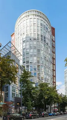 a tall building with cars parked in front of it at The Urban Lofts in Vancouver