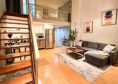 a living room with a couch and a kitchen at The Urban Lofts in Vancouver