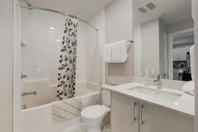 a bathroom with a toilet and a sink and a shower at Free Underground Parking, Pet Friendly Apartment in Calgary