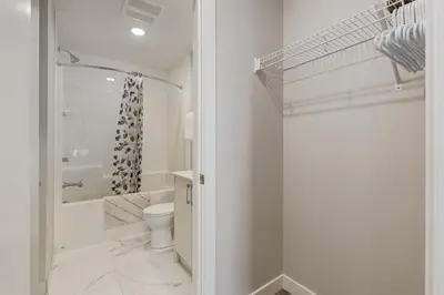 a white bathroom with a toilet and a shower at Free Underground Parking, Pet Friendly Apartment in Calgary