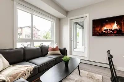 a living room with a couch and a fireplace at Free Heated Parking, Quick DT Access in Calgary