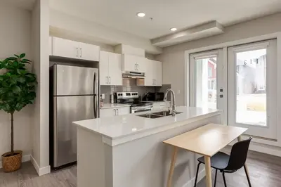 a kitchen with white cabinets and a refrigerator at Free Heated Parking, Close to DT, Pet Friendly in Calgary