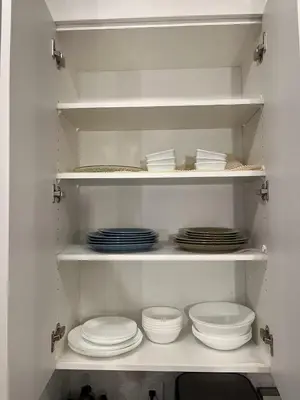 a kitchen with white plates and dishes on shelves at Luxurious, Centrally Located Home in Cavanagh in Edmonton
