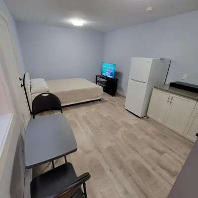 a small room with a bed and a refrigerator at Gladiola Bed & Breakfast in Victoria