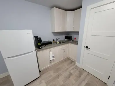 a kitchen with white cabinets and a white refrigerator at Gladiola Bed & Breakfast in Victoria