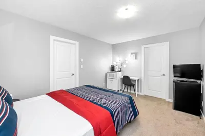 a bedroom with a bed and a desk and a television at Home away from Home in Victoria