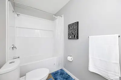 a white bathroom with a toilet and a shower at Home away from Home in Victoria