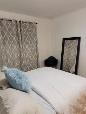 a bed with a blue pillow on top of it at Covepark house in Calgary