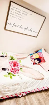 a sign above a bed with flowers on it at Casa Andrei in Edmonton