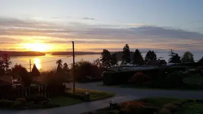 a view of a sunset from a house at Cozy Quiet Suite with Private Hot Tub with Ocean Views in Nanaimo