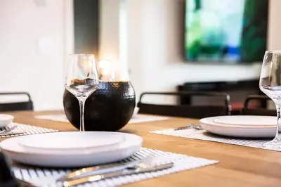 a table with two wine glasses and plates on it at Lucid Lemming in Revelstoke