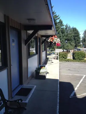 a sidewalk outside of a building with a bench at Departure Bay Motel in Nanaimo