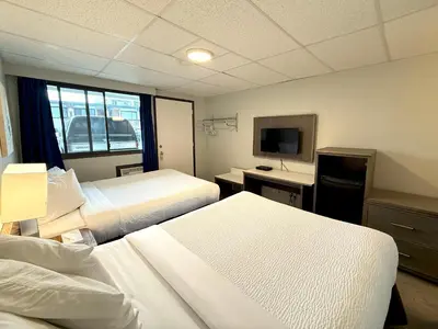 a hotel room with two beds and a television at Departure Bay Motel in Nanaimo