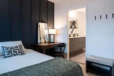 a bedroom with a bed and a desk and a mirror at Knuckle Hucks by Revelstoke Vacations in Revelstoke