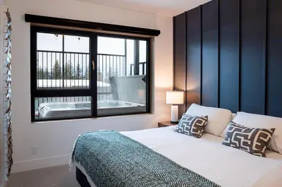 a bedroom with a large bed and a window at Knuckle Hucks by Revelstoke Vacations in Revelstoke