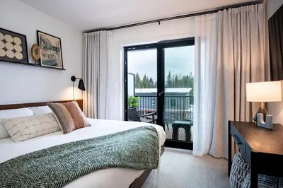 a hotel room with a bed and a large window at Knuckle Hucks by Revelstoke Vacations in Revelstoke