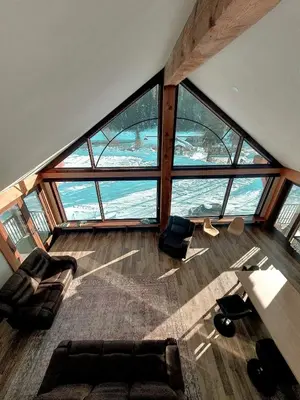 a living room with a large group of windows at River Safari Mountain View Suite in Blue River