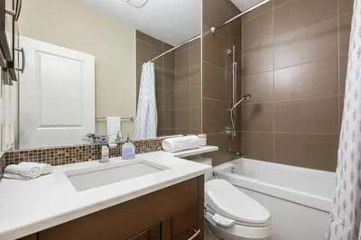 a bathroom with a sink and a toilet and a tub at Golden View Manor in Calgary
