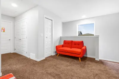 an orange chair in a white room with a window at Private Master Bed Room SPRING in Edmonton