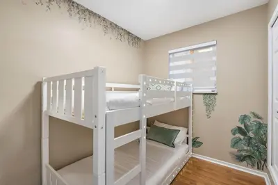 a white bunk bed in a room with a window at Spacious Family Retreat Central to YVR and Downtown in Vancouver