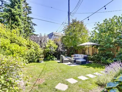 a garden with a couch and an umbrella at Private Suite With Spacious Yard in Vancouver