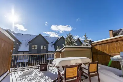 a patio with two chairs and a table on a balcony at Stunning Central Canmore Condo in Canmore
