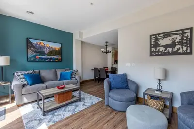 a living room with a couch and chairs and a table at Newly Renovated Rocky Mountain Canmore Chalet in Canmore