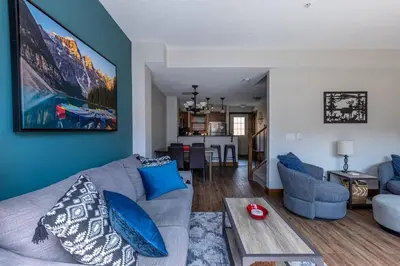 a living room with a gray couch and blue walls at Newly Renovated Rocky Mountain Canmore Chalet in Canmore