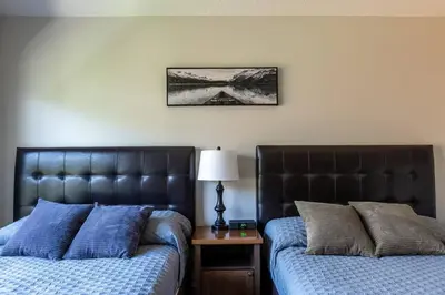 two beds sitting next to each other in a bedroom at Newly Renovated Rocky Mountain Canmore Chalet in Canmore