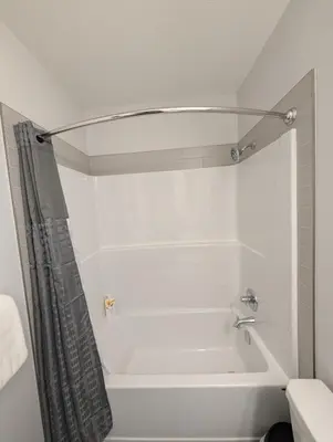 a white bath tub with a shower curtain in a bathroom at DaraJay Cozy Home in Calgary