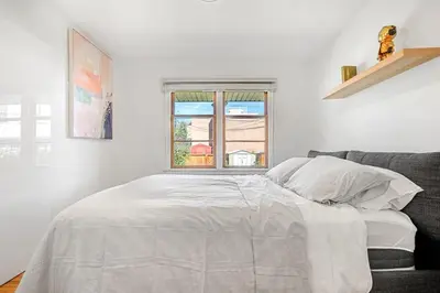 a white bedroom with a bed and a window at 5 bed Luxury Home Steps to DT, River and Hospital in Calgary