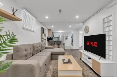 a living room with a couch and a tv at 5 bed Luxury Home Steps to DT, River and Hospital in Calgary